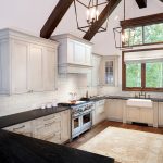 Bright kitchen with white cabinets and wooden beams.