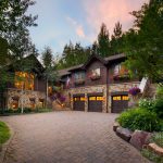 Cozy mountain cabin with warm lights at dusk.